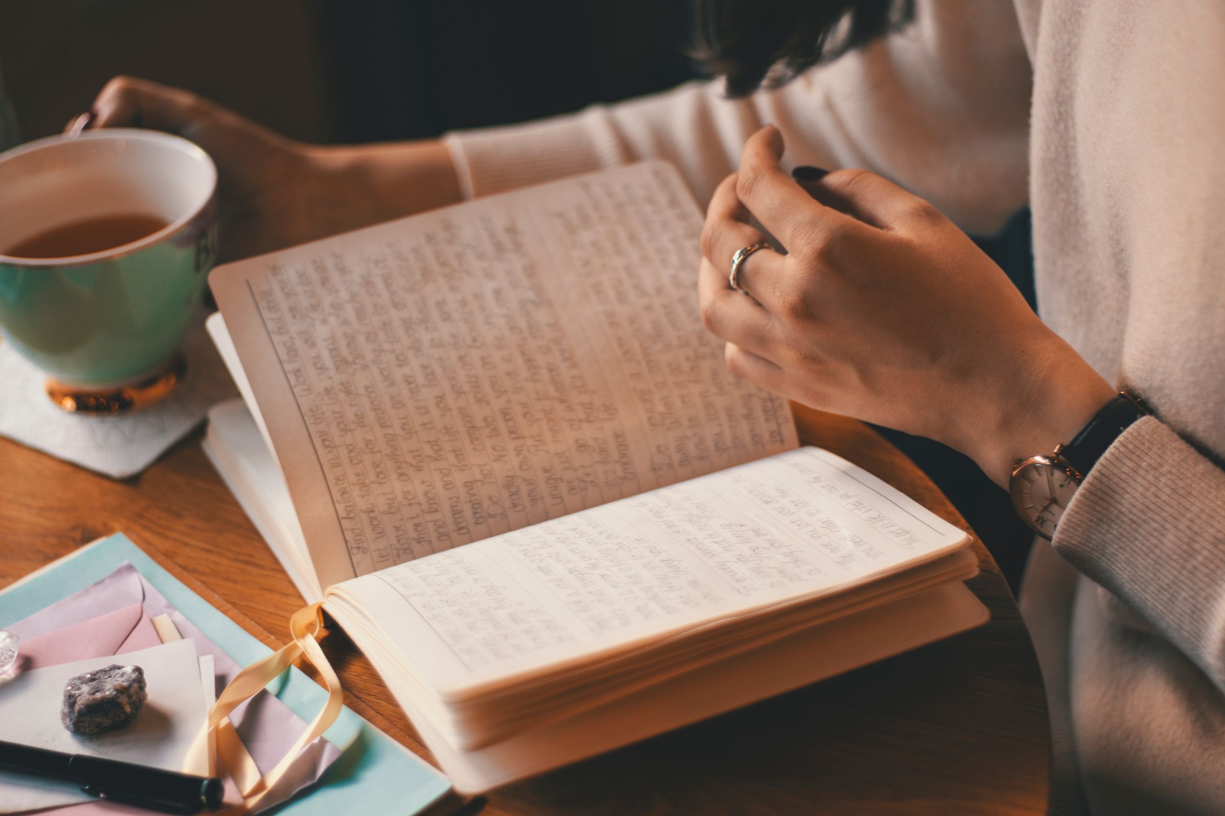 Reading printed papers with notes and a cup of tea