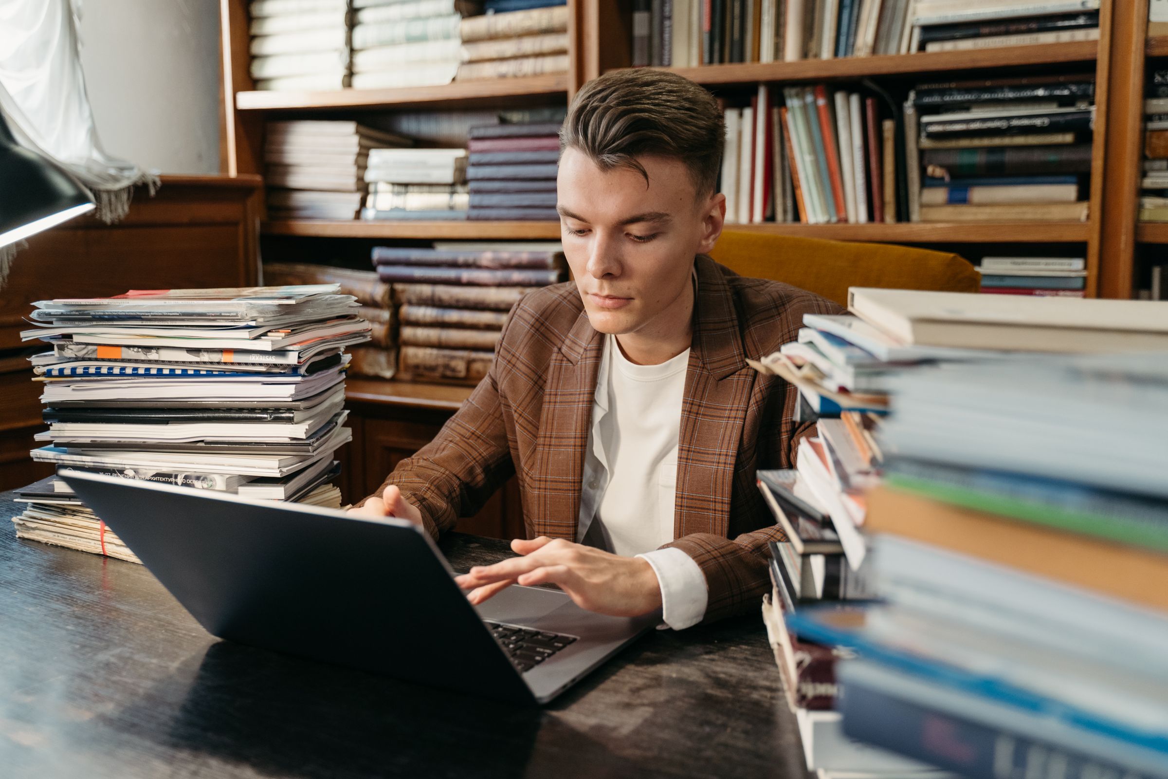 A researcher with books and a laptop